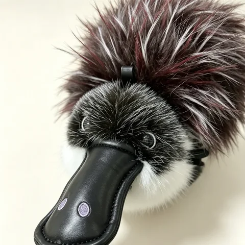 Close-up of Platy's glossy PU leather duck bill, embroidered nostrils and dense two-tone fur